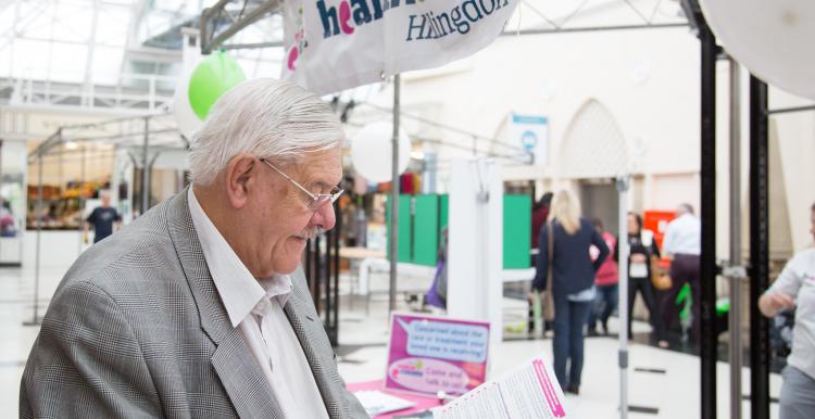 Elderly man at event reading leaflet