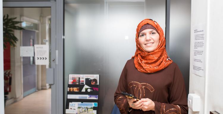 woman wearing a headscarf holding her mobile phone