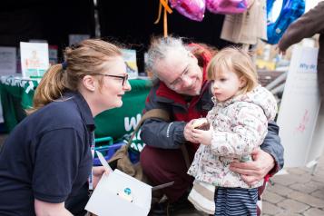 Healthwatch Volunteer talking to a little girl and her dad