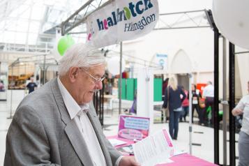 Elderly man at event reading leaflet