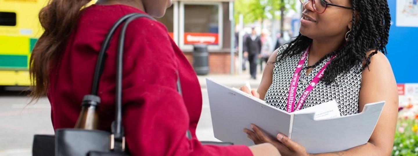 Healthwatch volunteer talking to patient outside hospital