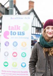 Young woman in front of Healthwatch sign