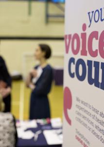 Women talking with Healthwatch 'your voice counts' sign in front at event